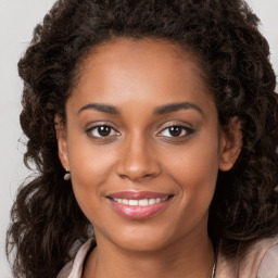 Joyful black young-adult female with long  brown hair and brown eyes