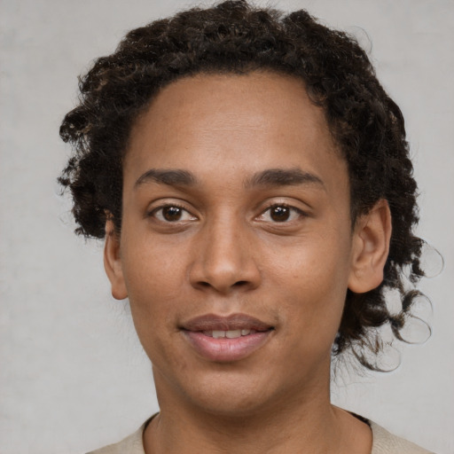 Joyful black young-adult male with short  brown hair and brown eyes
