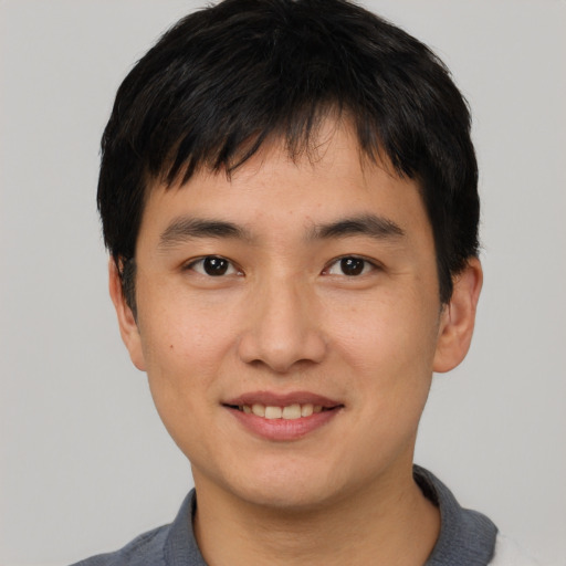Joyful asian young-adult male with short  black hair and brown eyes
