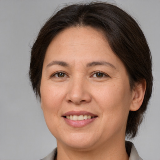 Joyful white adult female with medium  brown hair and brown eyes