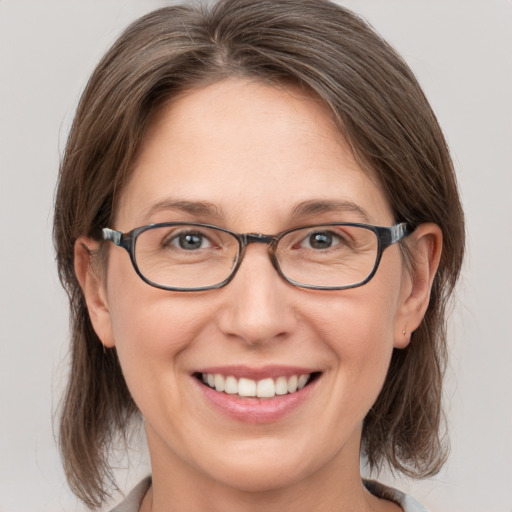 Joyful white adult female with medium  brown hair and grey eyes