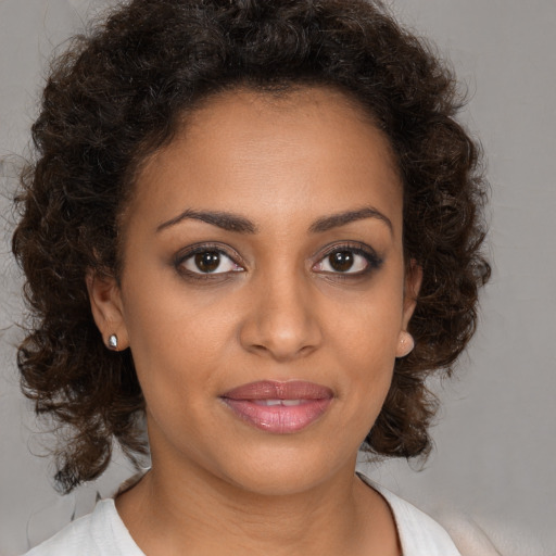 Joyful black young-adult female with medium  brown hair and brown eyes