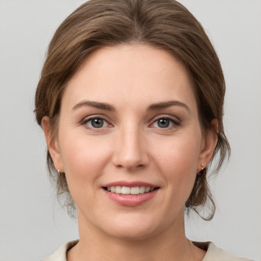 Joyful white young-adult female with medium  brown hair and grey eyes