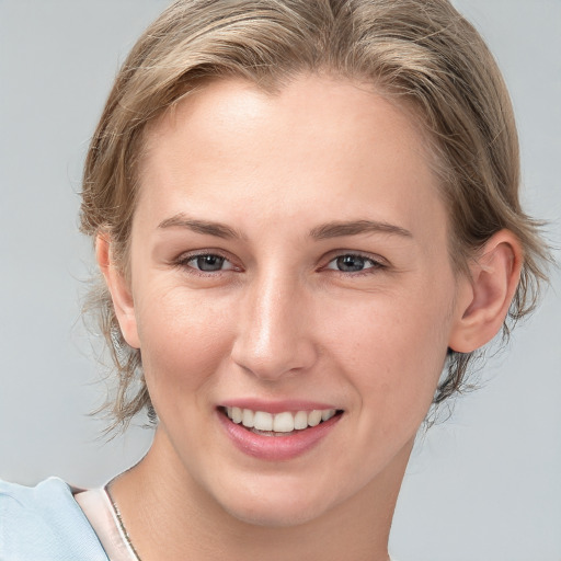 Joyful white young-adult female with medium  brown hair and blue eyes