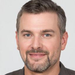 Joyful white adult male with short  brown hair and brown eyes