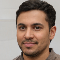 Joyful white young-adult male with short  black hair and brown eyes