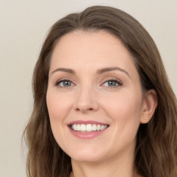 Joyful white young-adult female with long  brown hair and green eyes