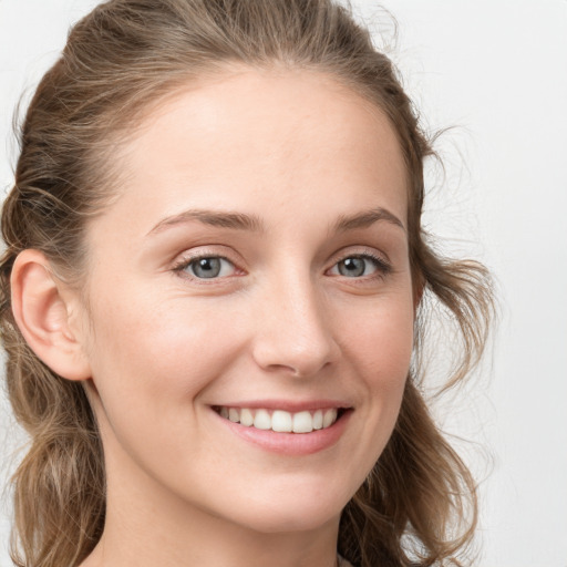 Joyful white young-adult female with long  brown hair and blue eyes