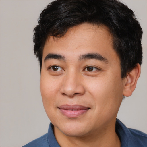 Joyful asian young-adult male with short  black hair and brown eyes