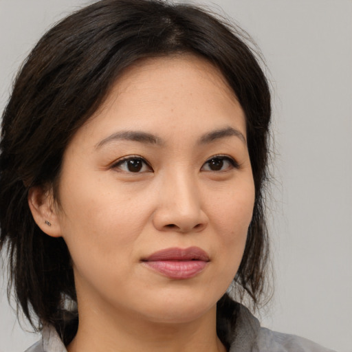 Joyful asian young-adult female with medium  brown hair and brown eyes