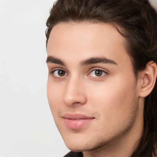 Joyful white young-adult male with long  brown hair and brown eyes