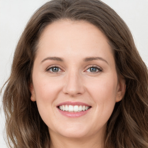 Joyful white young-adult female with long  brown hair and green eyes