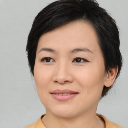 Joyful asian young-adult female with medium  brown hair and brown eyes