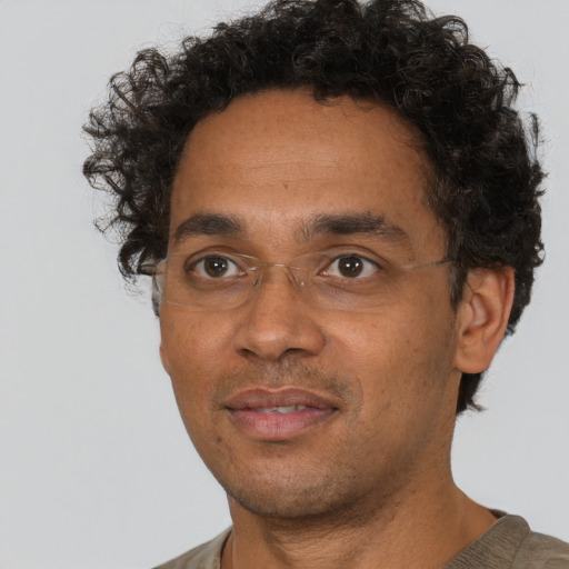Joyful black adult male with short  black hair and brown eyes