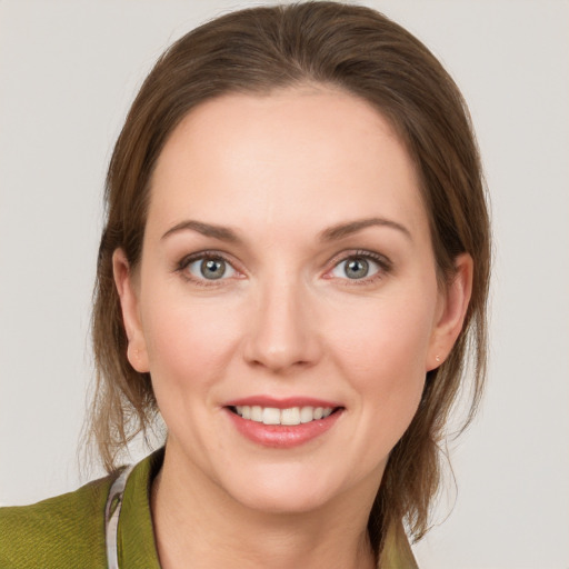 Joyful white young-adult female with medium  brown hair and grey eyes