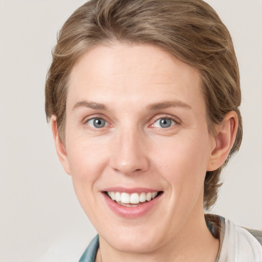 Joyful white adult female with medium  brown hair and blue eyes