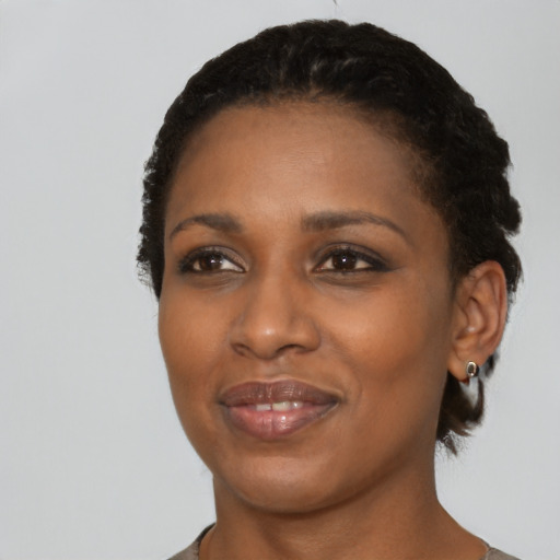 Joyful black young-adult female with short  black hair and brown eyes