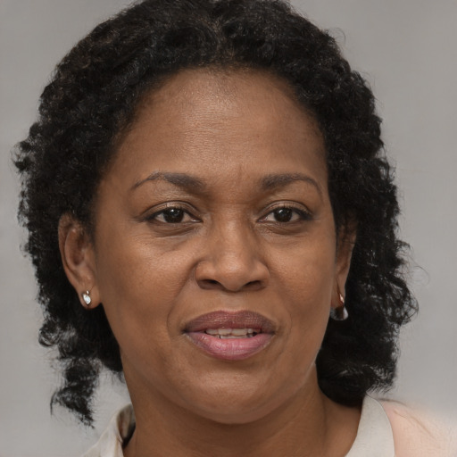 Joyful black adult female with medium  brown hair and brown eyes