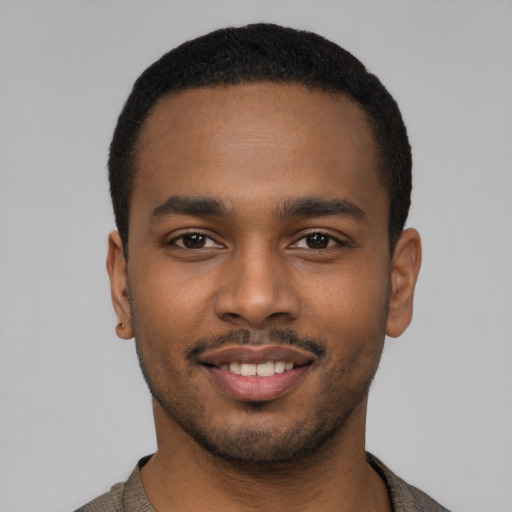 Joyful black young-adult male with short  black hair and brown eyes