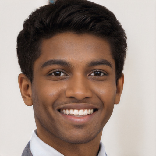 Joyful black young-adult male with short  black hair and brown eyes