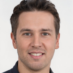 Joyful white young-adult male with short  brown hair and grey eyes