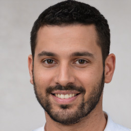 Joyful white young-adult male with short  black hair and brown eyes