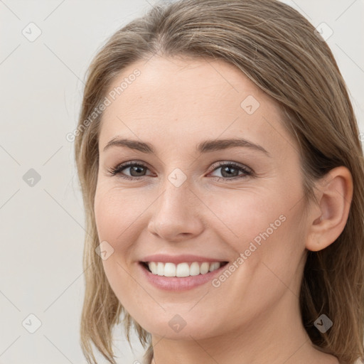 Joyful white young-adult female with medium  brown hair and grey eyes