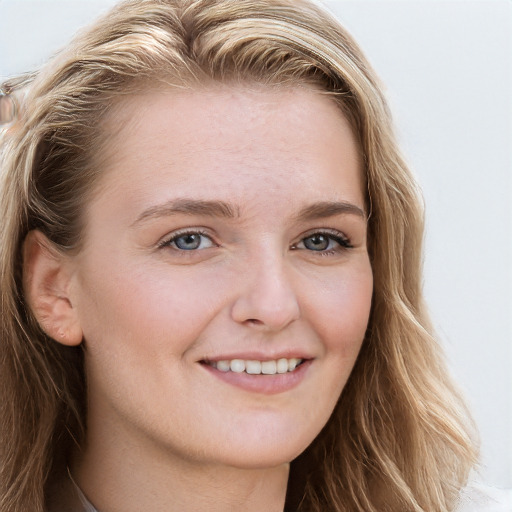 Joyful white young-adult female with long  brown hair and blue eyes