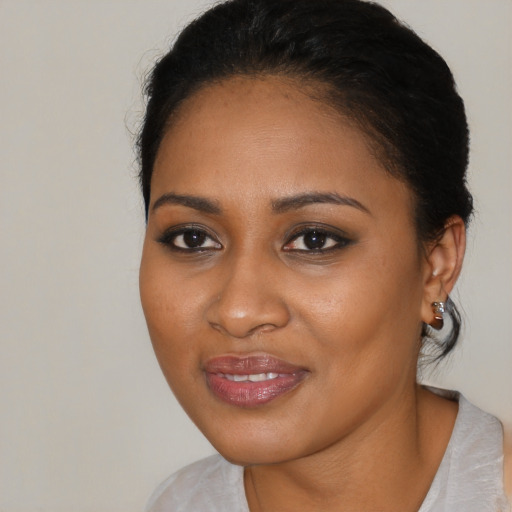 Joyful black young-adult female with medium  black hair and brown eyes