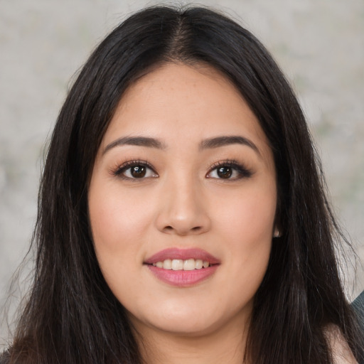 Joyful latino young-adult female with long  brown hair and brown eyes