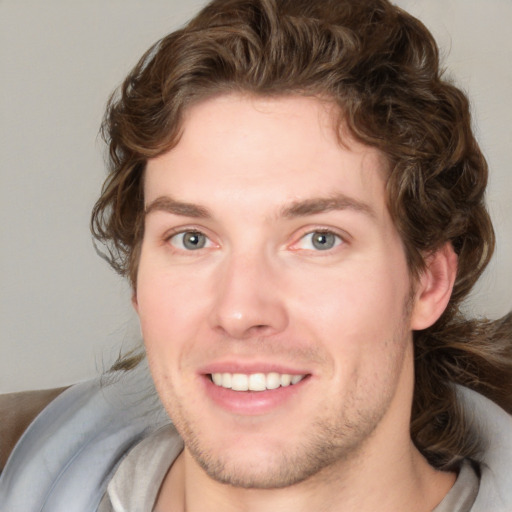 Joyful white young-adult male with medium  brown hair and blue eyes