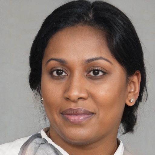 Joyful black young-adult female with medium  brown hair and brown eyes