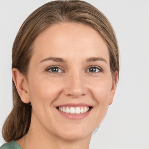 Joyful white young-adult female with medium  brown hair and grey eyes