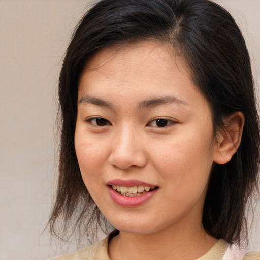 Joyful asian young-adult female with medium  brown hair and brown eyes