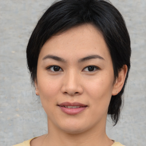 Joyful asian young-adult female with medium  black hair and brown eyes