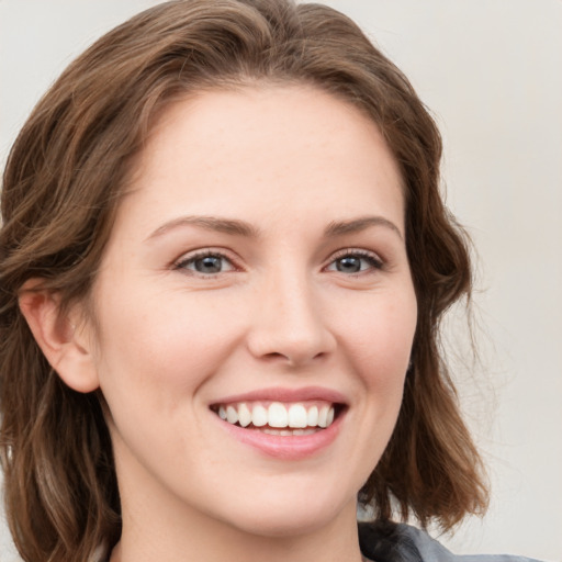 Joyful white young-adult female with medium  brown hair and blue eyes