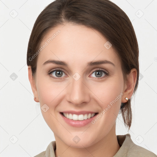 Joyful white young-adult female with medium  brown hair and grey eyes