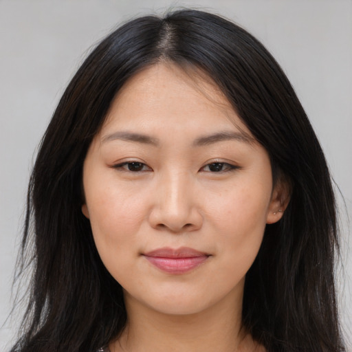 Joyful asian young-adult female with long  brown hair and brown eyes