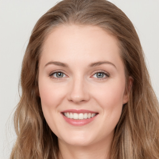 Joyful white young-adult female with long  brown hair and blue eyes