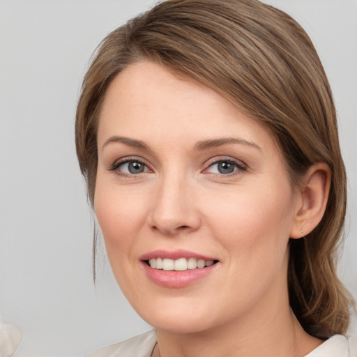 Joyful white young-adult female with medium  brown hair and grey eyes