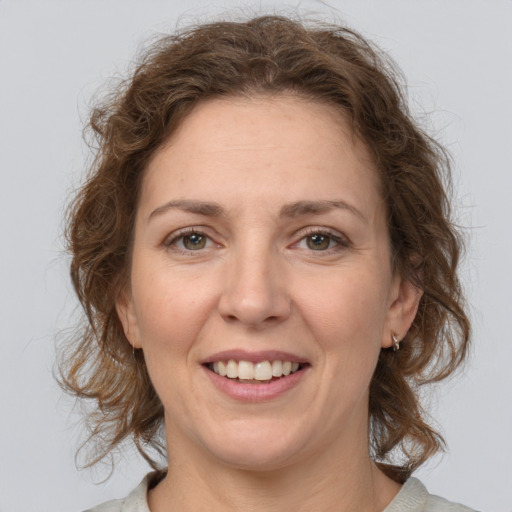 Joyful white adult female with medium  brown hair and grey eyes