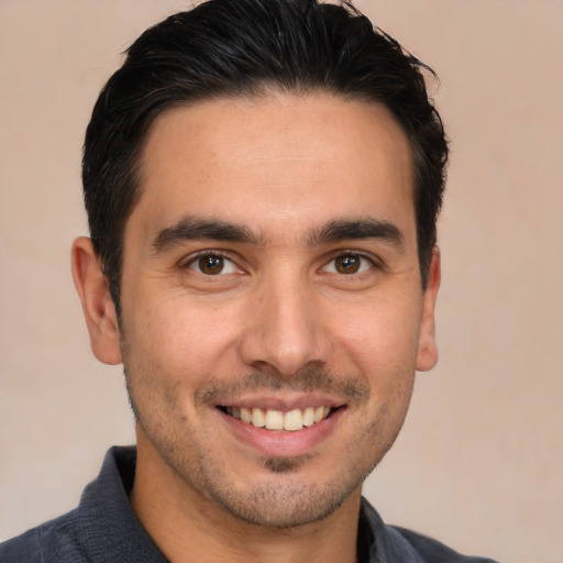 Joyful white young-adult male with short  black hair and brown eyes