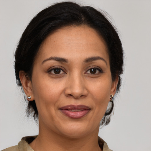 Joyful latino adult female with medium  brown hair and brown eyes