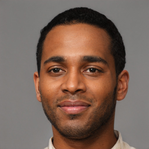 Joyful black young-adult male with short  black hair and brown eyes