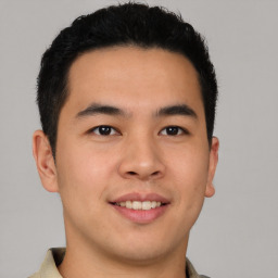 Joyful latino young-adult male with short  brown hair and brown eyes