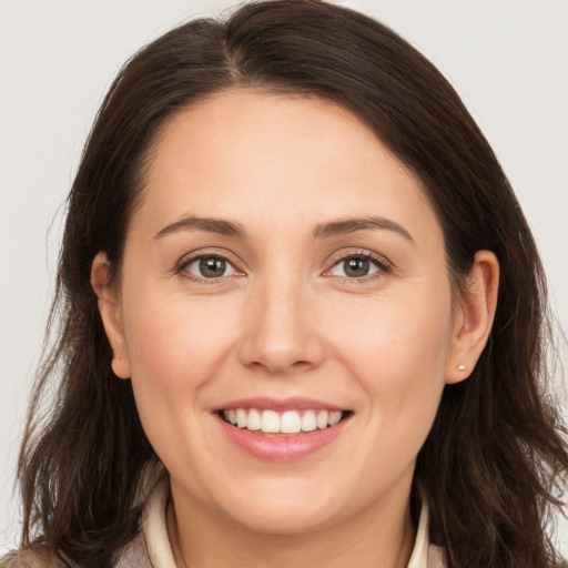 Joyful white young-adult female with long  brown hair and brown eyes