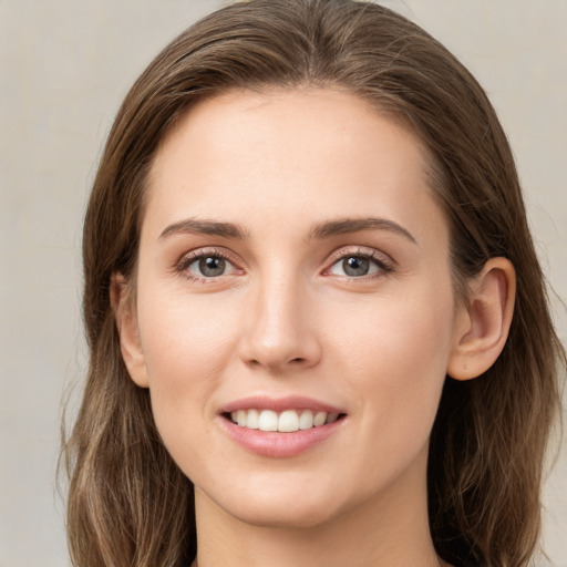 Joyful white young-adult female with long  brown hair and grey eyes