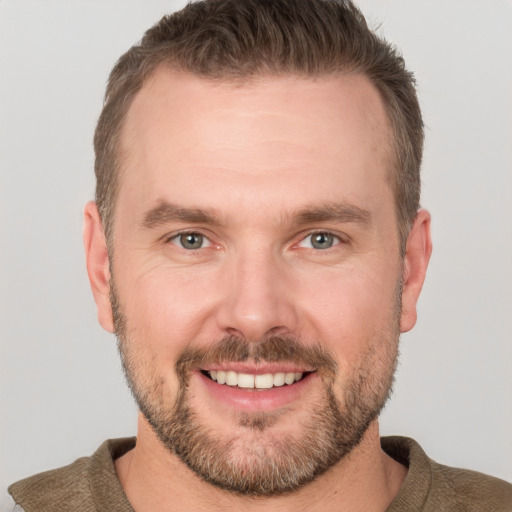 Joyful white adult male with short  brown hair and grey eyes