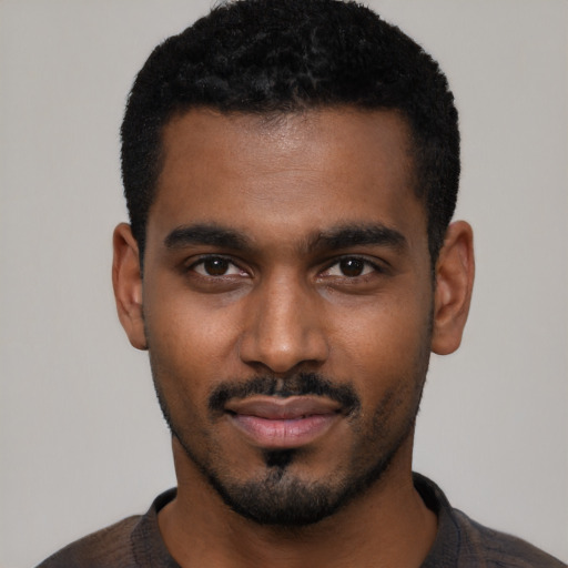 Joyful black young-adult male with short  black hair and brown eyes