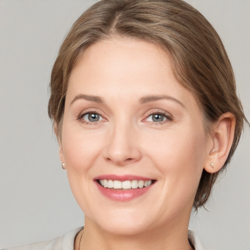 Joyful white young-adult female with medium  brown hair and grey eyes